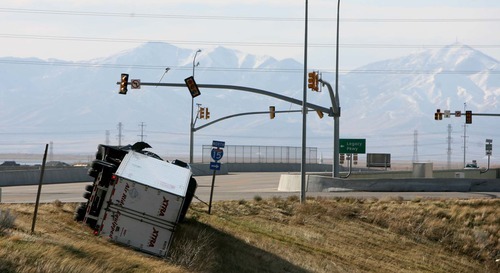 Leah Hogsten | The Salt Lake Tribune  
A semitruck toppled in the wind on Park Lane in Farmington. Hurricane-force winds, in places topping 100 mph, ripped through Utah on Thursday, overturning semitrailer rigs on Interstate 15, toppling trees and triggering widespread power outages affecting nearly 50,000 homes and businesses.